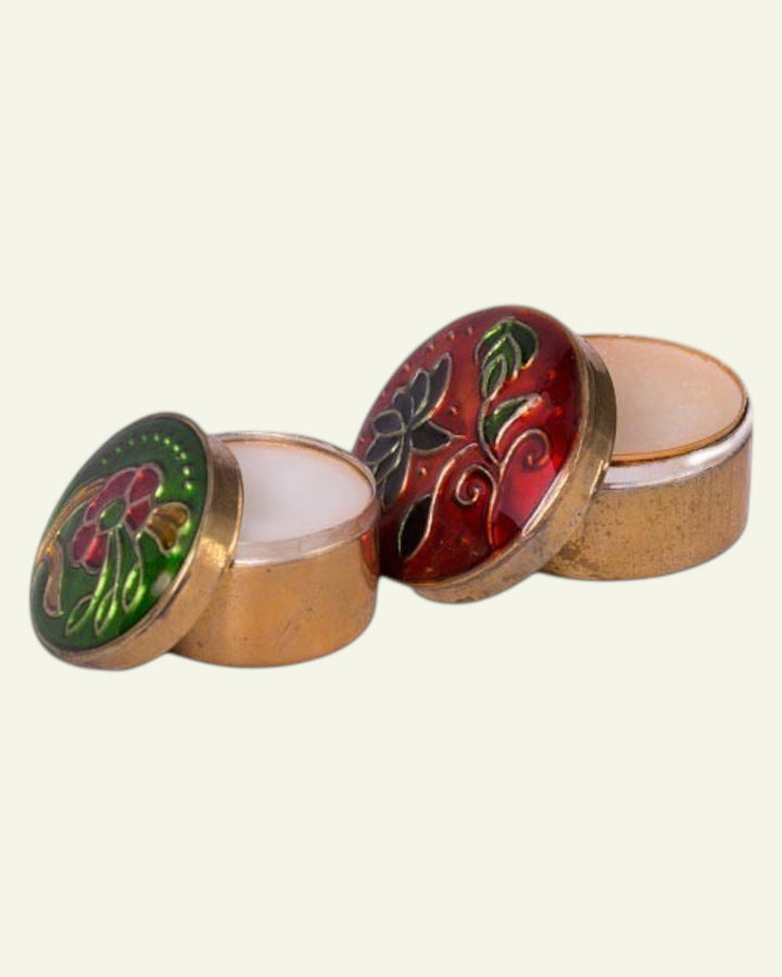 ULA creme perfume in decorative gold tins with floral enamel designs in red and green.